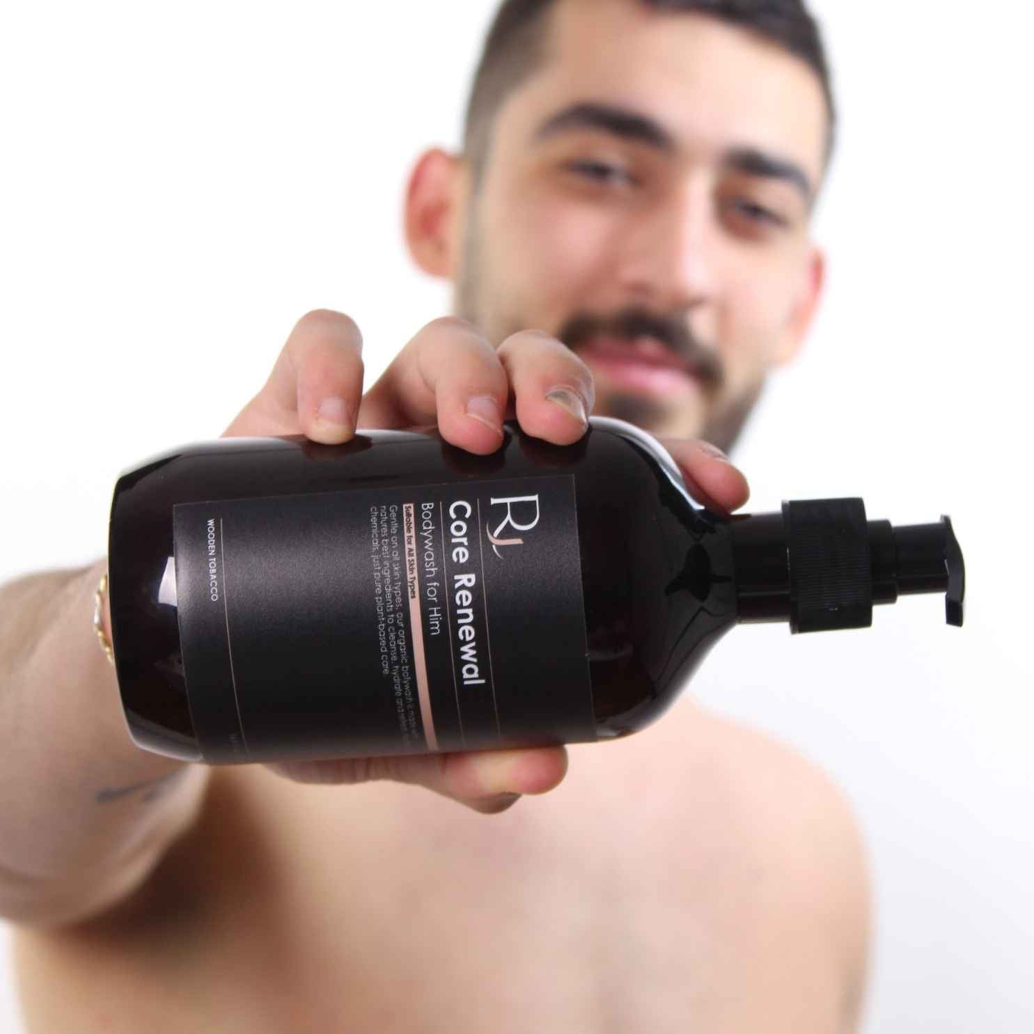 Model holding Raqiia Core Renewal Bodywash in front of white background