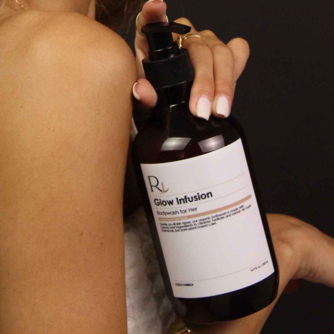 Bottle of 'Raqiia Glow Infusion' body wash held by a person with a blurred background