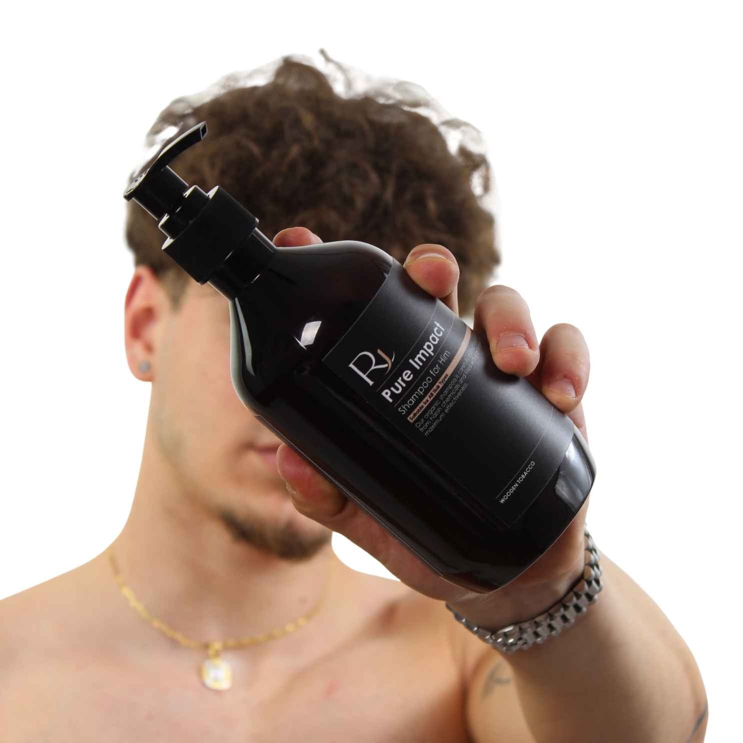 Person holding an amber bottle labeled 'Raqiia Pure Impact' with a blurred background