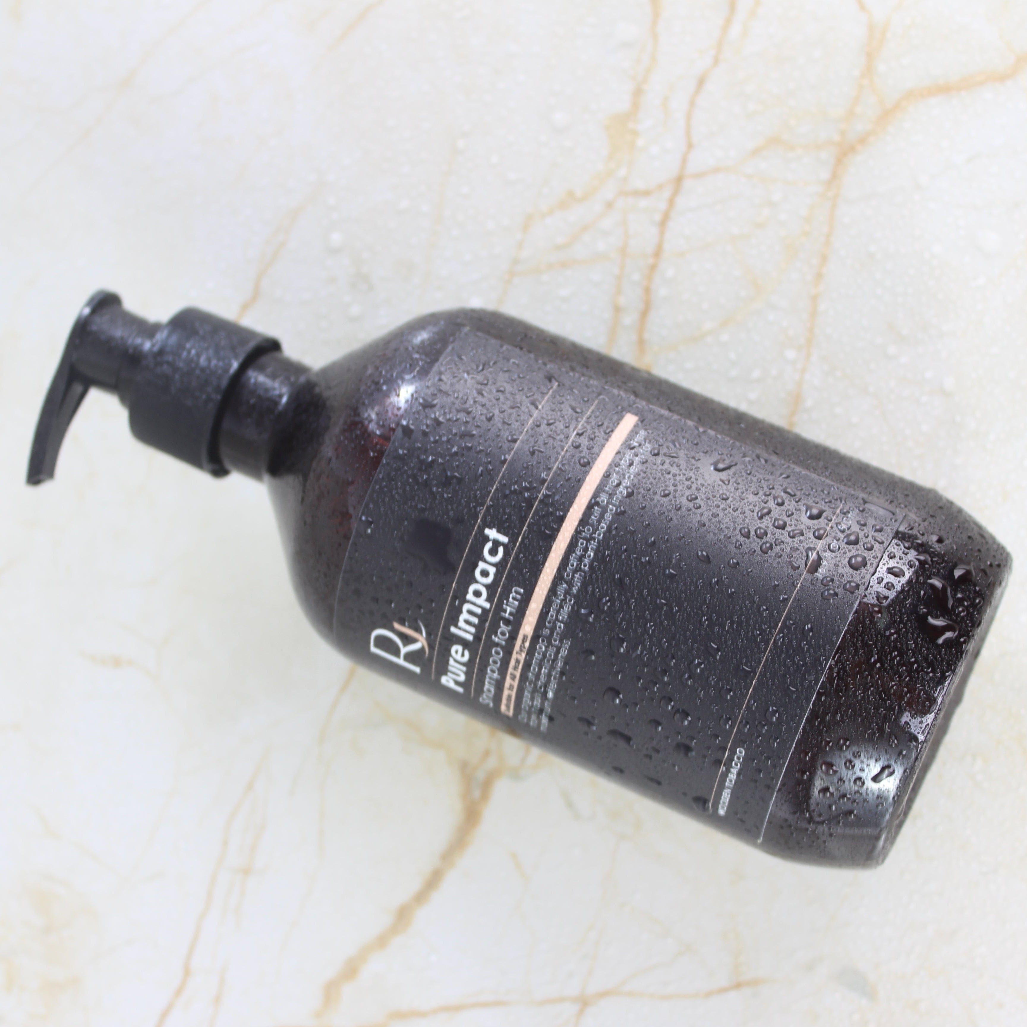 Amber Raqiia Pure Impact Shampoo bottle with pump on a marble surface