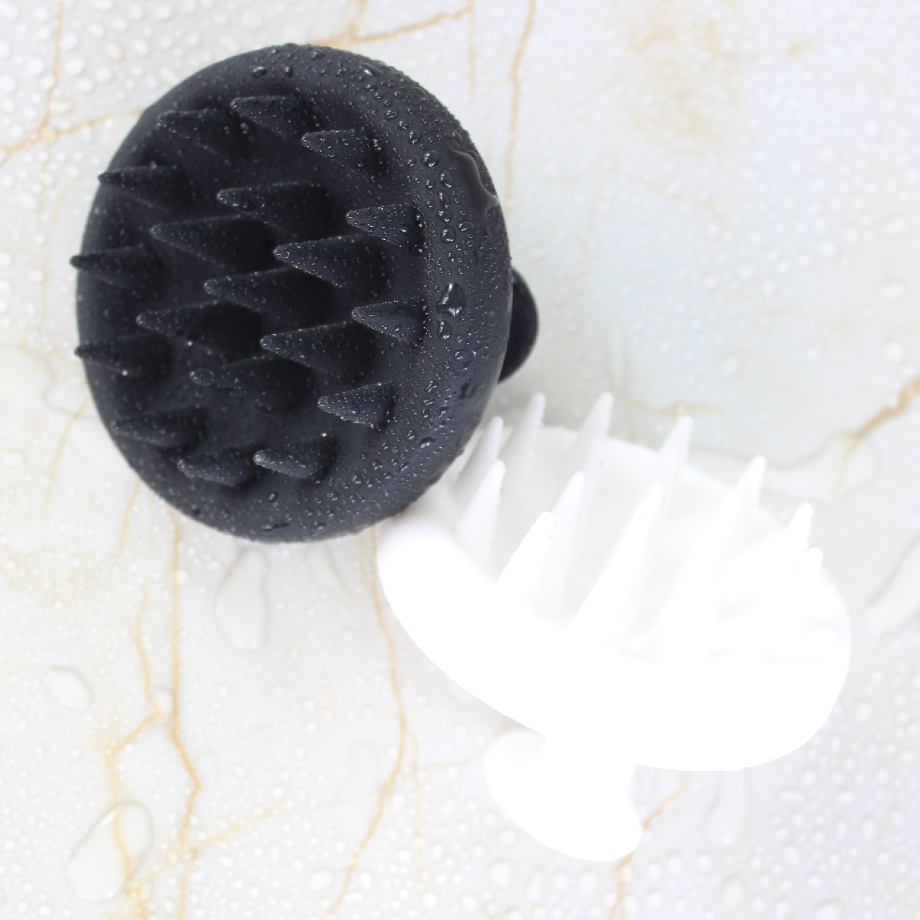Black and White Raqiia Scalp Massagers on gold marble