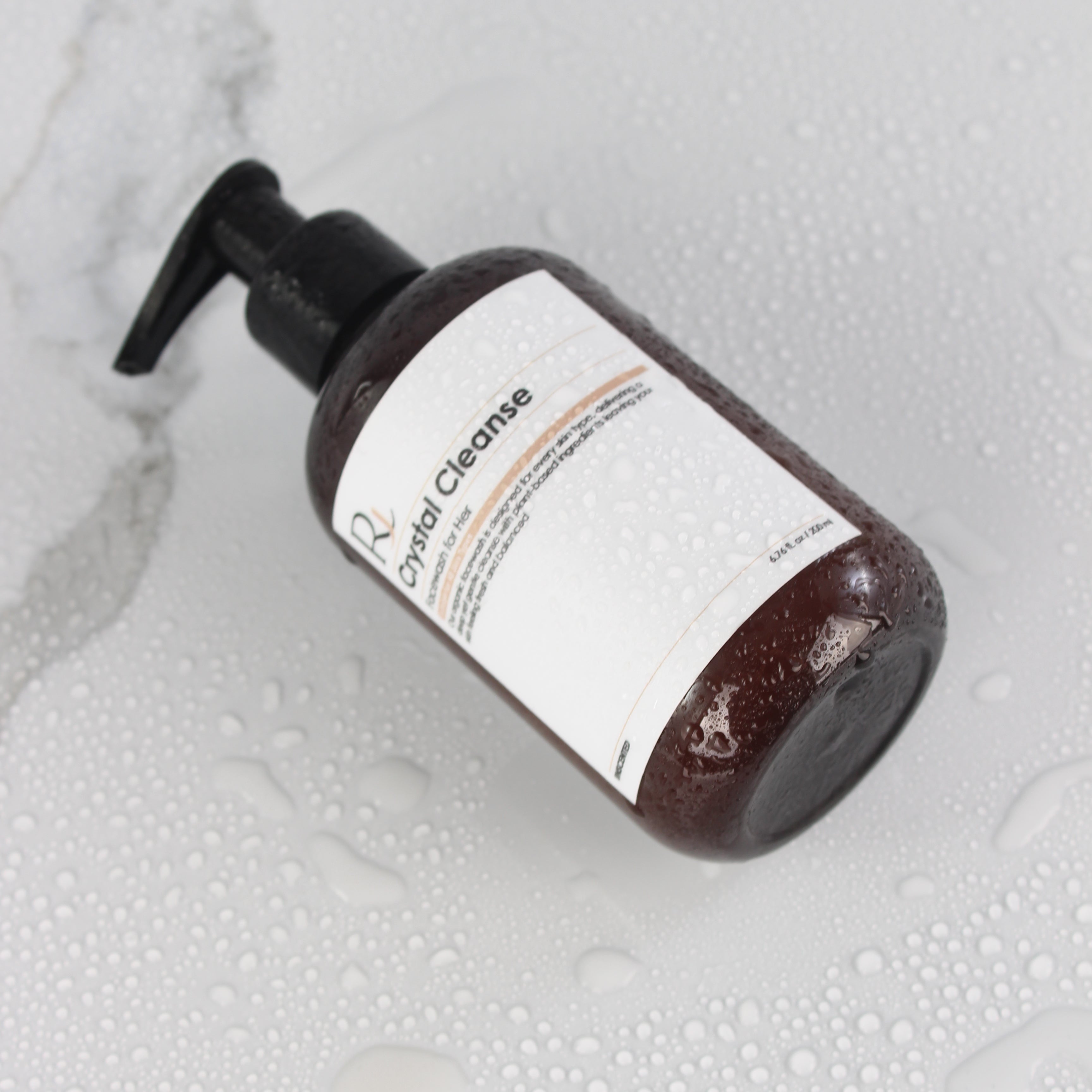 Bottle of 'Raqiia Crystal Cleanse Facewash' on a textured white surface