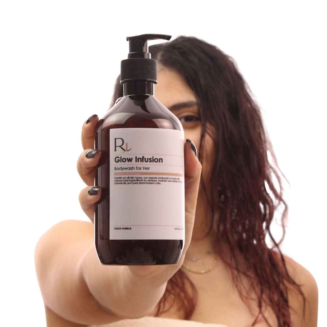 Person holding a bottle of 'Raqiia Glow Infusion' bodywash for hair with a visible brand logo.