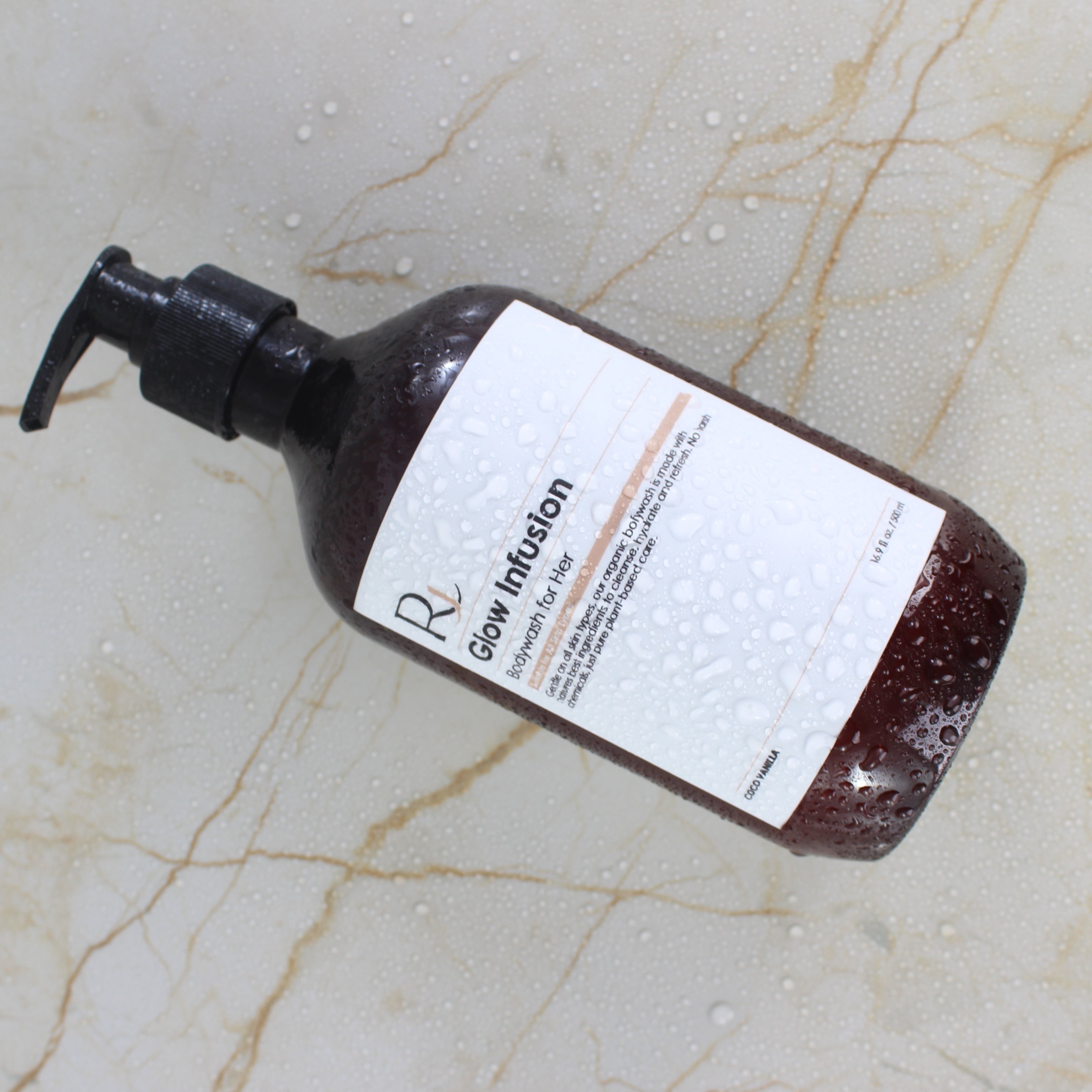 Bottle of Raqiia Glow Infusion Bodywash with a label on a marble surface